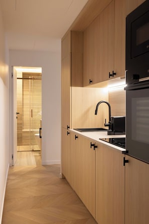 Une cuisine moderne avec des meubles en bois, un robinet noir et un four encastré.