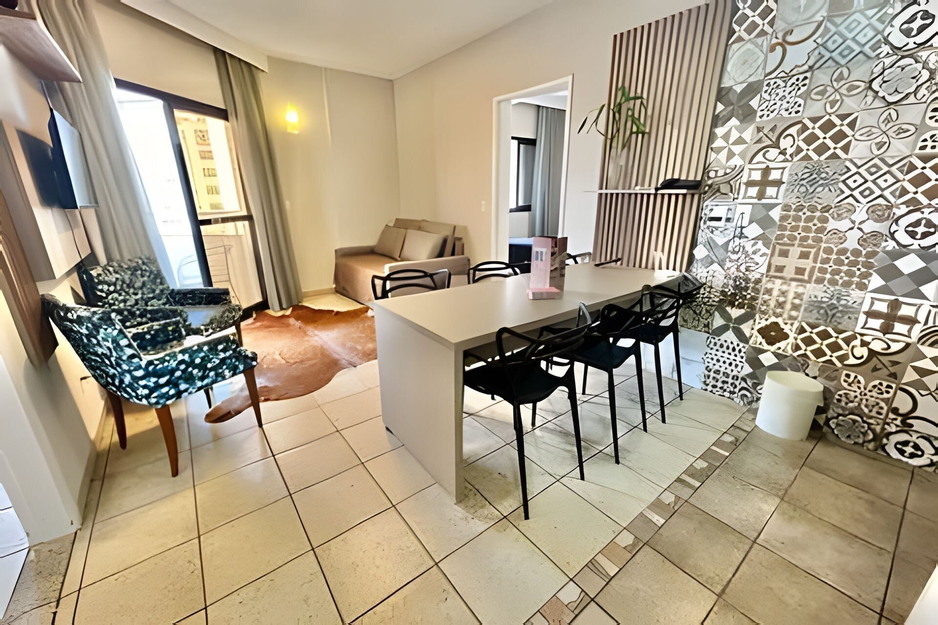 Uma sala de estar moderna com área de jantar, um sofá e uma mesa de centro.
