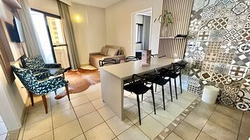 Uma sala de estar moderna com área de jantar, um sofá e uma mesa de centro.