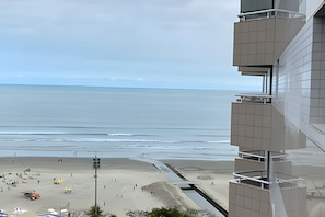 Un edificio alto con vista a la playa y al océano.