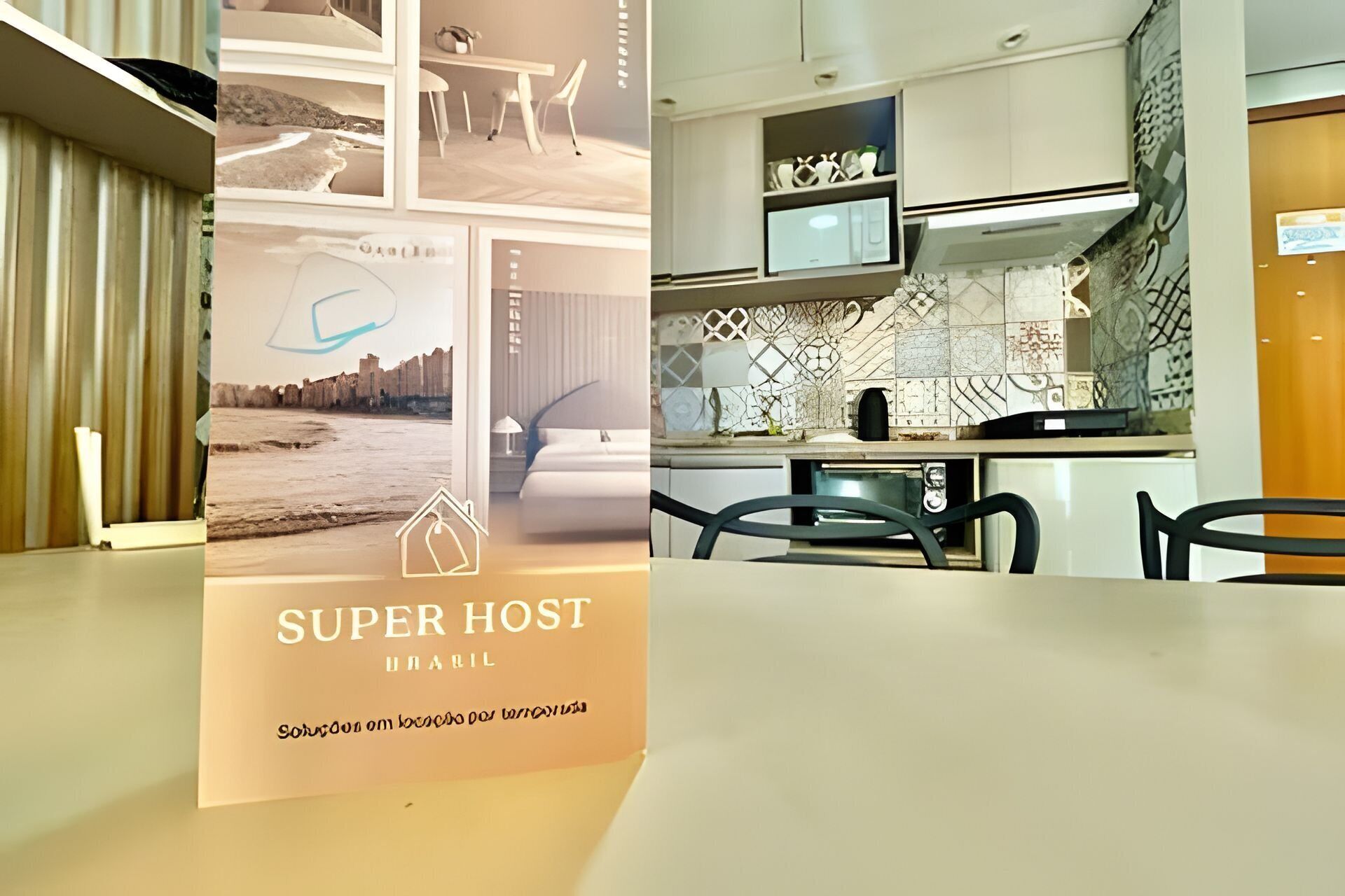 Un folleto de 'Super Host Brasil' que muestra una cocina moderna con armarios blancos, microondas y salpicadero de azulejos.