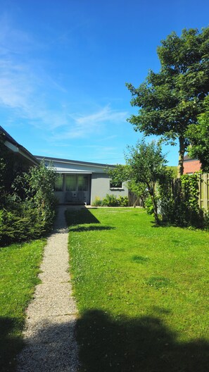 Il s’agit d’une propriété résidentielle, avec un chemin de gravier menant à une maison dotée d’un porche à l’avant.
