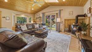 Een gezellige woonkamer met leren banken, een open haard en een plafondventilator.