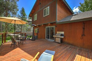 A wooden deck with outdoor furniture, a grill, and a covered seating area. - The Rabbit Hole - Sauna. Soak. Repeat. (South Lake Tahoe)
