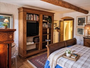 A bedroom with a wooden wardrobe, a bed with a checkered bedspread, and a wooden headboard. - Le Stanze degli Artisti by Case al Lago (Monzambano)