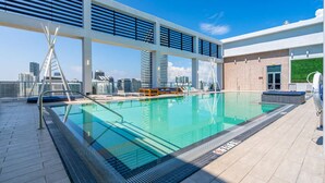 Ein Innenpool mit Blick auf die Stadtlandschaft, einem überdachten Sitzbereich und einem modernen architektonischen Design.
