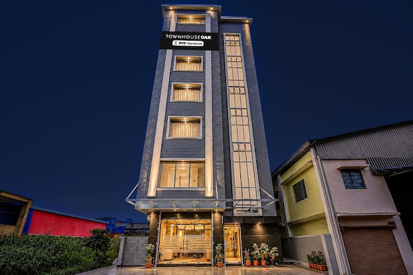A multi-story building with a sign indicating it is serviced by OYO.