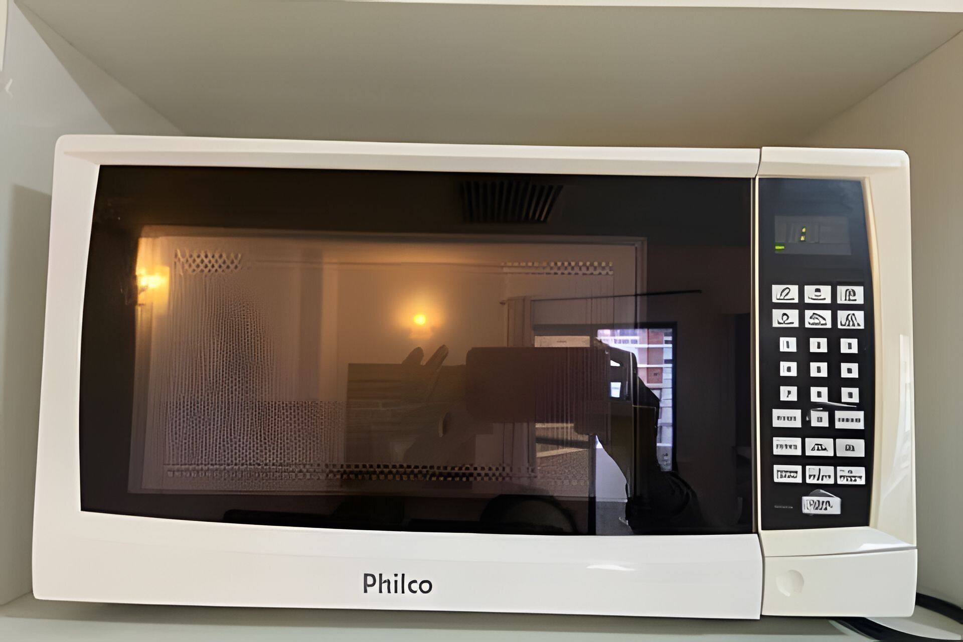 Un horno microondas Philco blanco con pantalla digital y panel de control.
