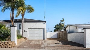 Una propietat residencial amb garatge, pati tancat i palmeres.