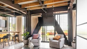 A modern living room with a sofa, armchairs, a coffee table, and a TV. - Argentina by Pardela (Guadalajara)