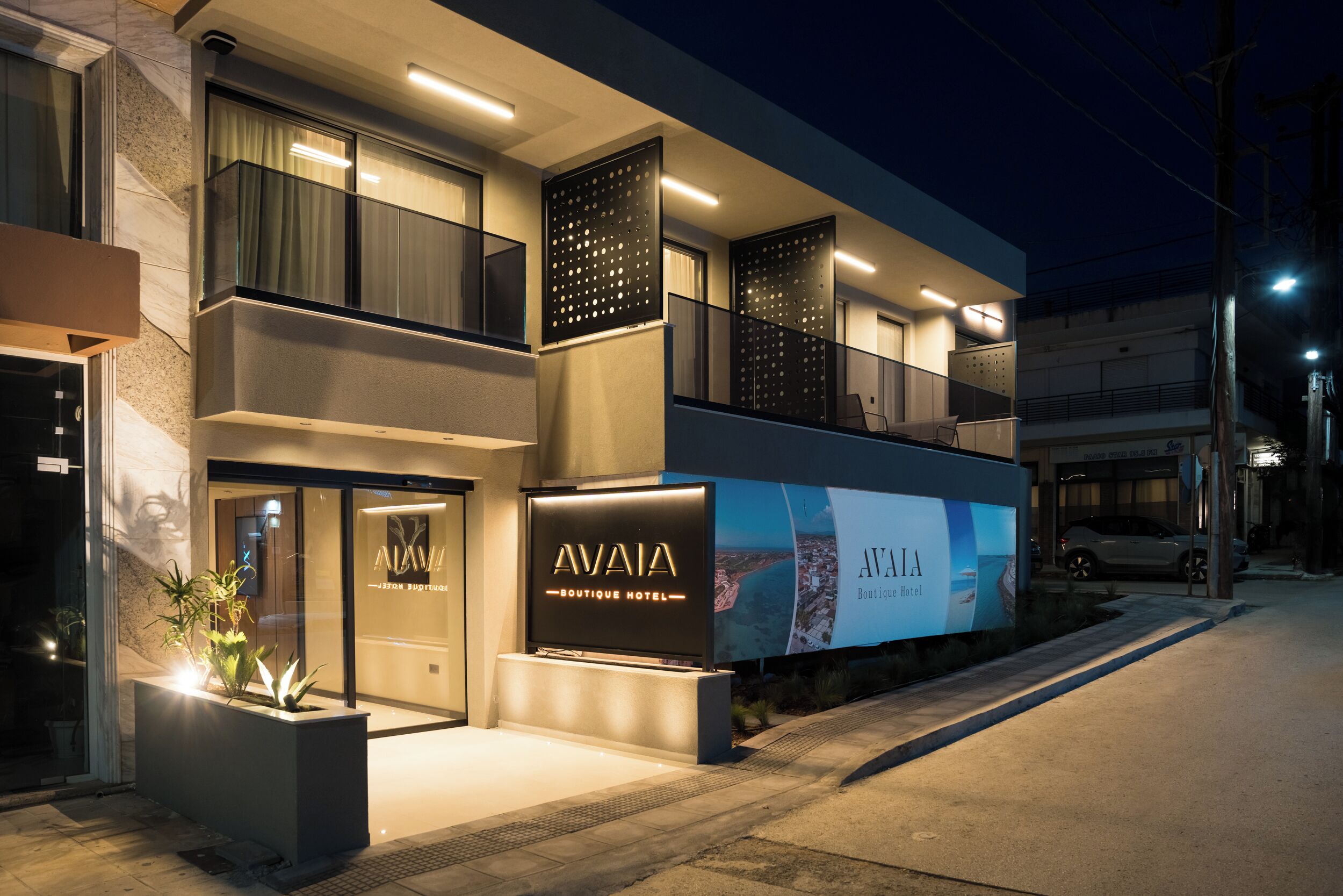 A modern boutique hotel with a prominent entrance, large windows, and a well-lit facade.
