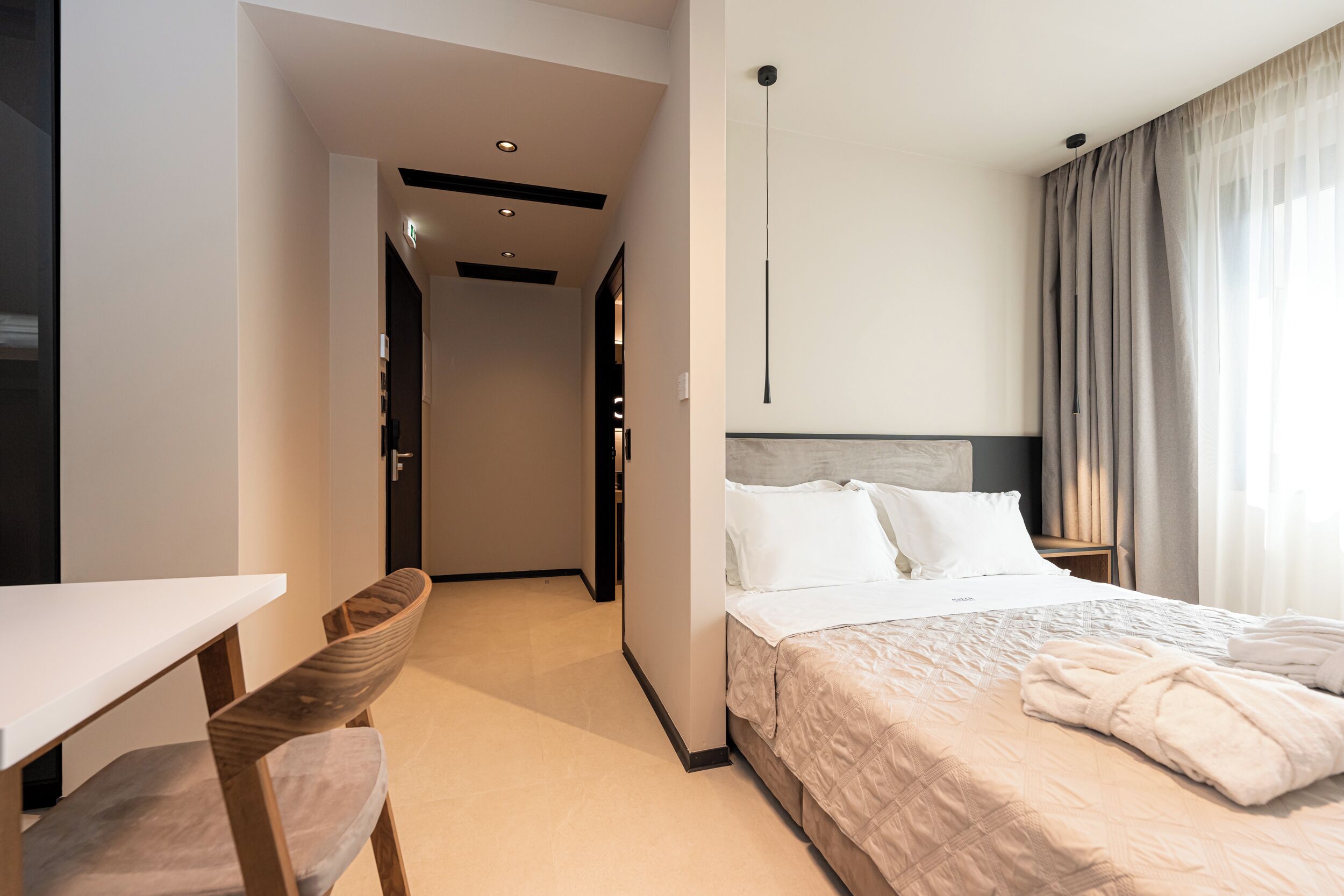 Une chambre d’hôtel avec un lit, un bureau et une chaise.