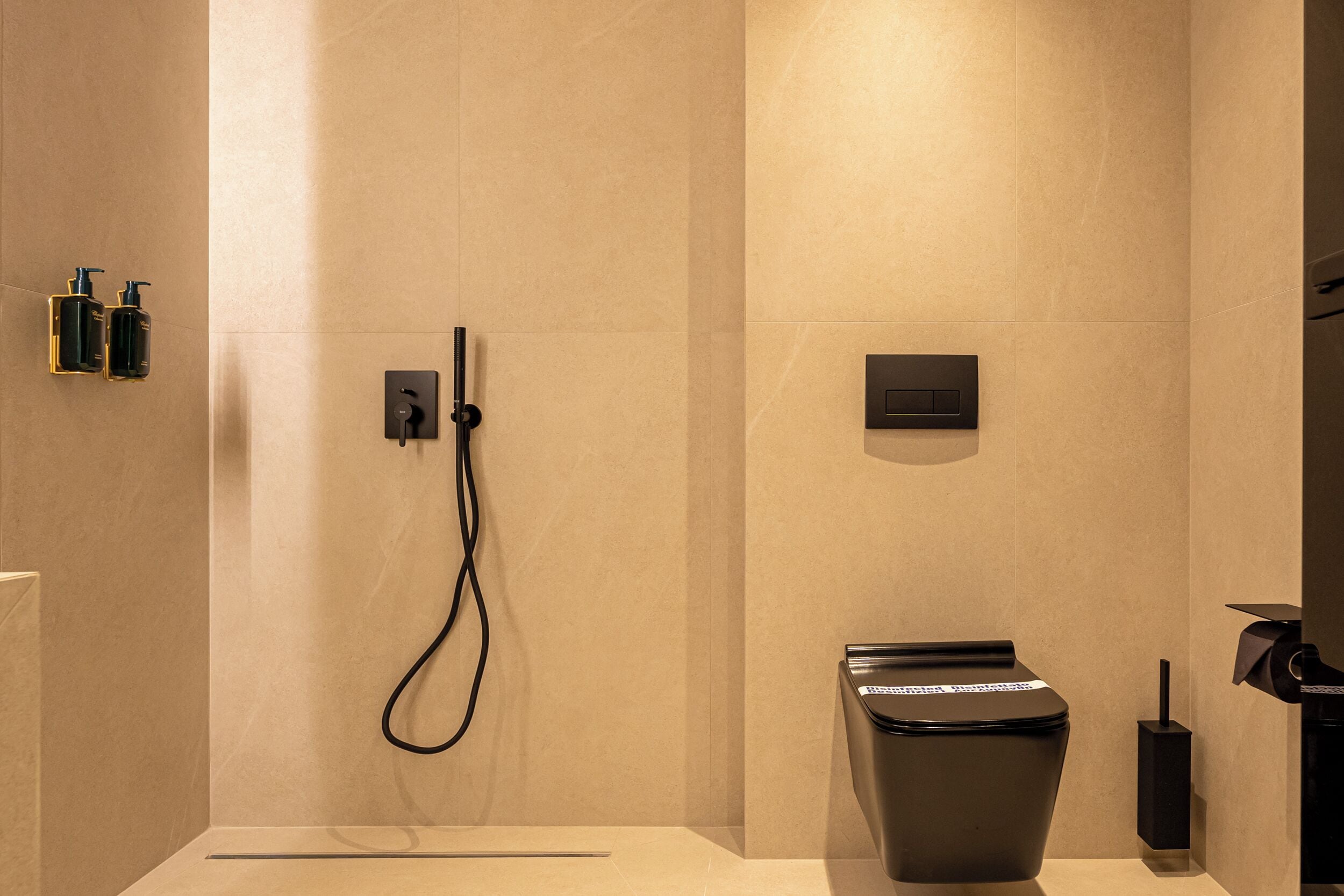 A modern bathroom with a shower, toilet, and hand dryer.