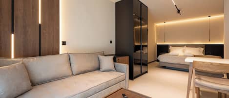 A modern living room with a sofa, a coffee table, and a dining area with a table and chairs.