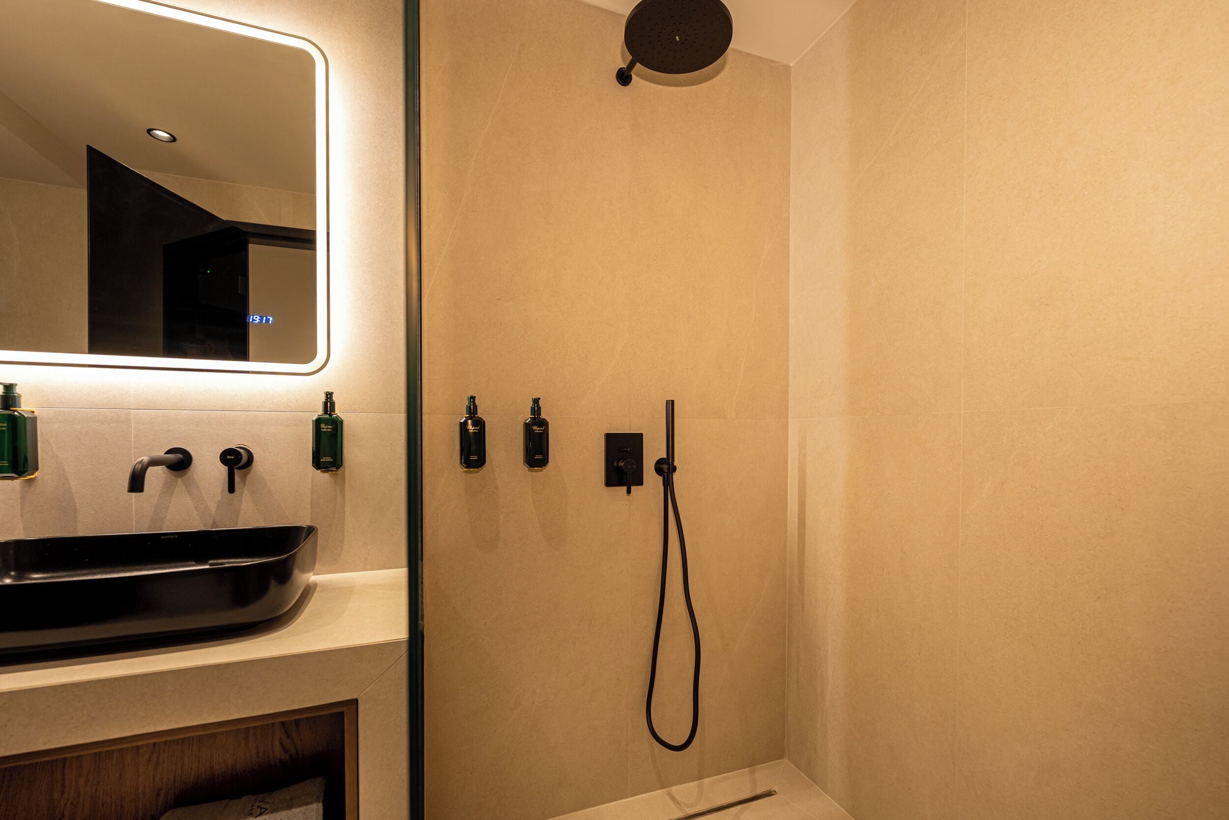 A bathroom with a sink, mirror, and shower.