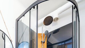 Une salle de bain moderne avec une douche à parois de verre, un meuble-lavabo en bois et un miroir.