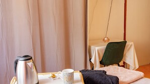 Une chambre à coucher avec un lit, une table de chevet, une télévision et un rideau.