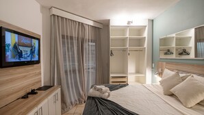 A hotel room with a bed, a TV, a wardrobe, and a mirror. - SHB Apartamento Com Vista ao Mar (Santos)