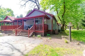 A two-story cabin with a porch, a covered front porch area, and a small outdoor seating area. - The Big Bear Retreat in Helen (Helen)