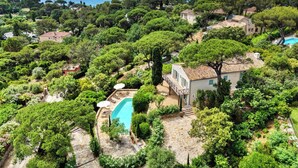 A residential area with a swimming pool surrounded by lush greenery and a view of the sea. - CASA-Fontaine Luxury Villa in Gigaro (Cavalaire-sur-Mer)