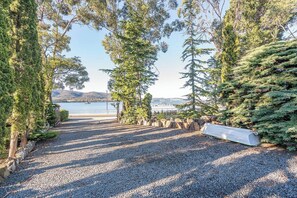 A gravel pathway leading to a beach with trees and a view of the water. - Southern Edge Retreat Vintage Charm by the Bay (Margate)