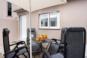 A patio with a table, chairs, a fruit bowl, and a window. - TenoHomes Sunny Terrace & Private Pool (Icod de los Vinos)