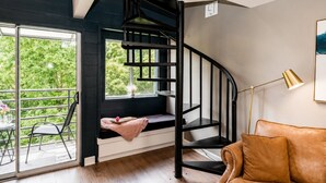 A modern interior with a spiral staircase, a seating area with a view, and a sofa. - Heavenly Hideaway | Indoor Outdoor Pools- Hot Tubs- Private Balcony (Gatlinburg)