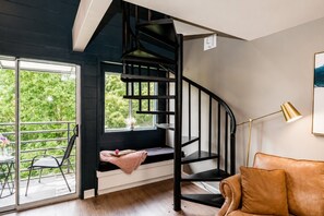 Ein modernes Interieur mit einer Wendeltreppe, einer Sitzecke mit Aussicht und einem Sofa.