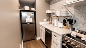 A modern kitchen with a stainless steel refrigerator, a built-in oven, and a microwave above the counter. - Heavenly Hideaway | Indoor Outdoor Pools- Hot Tubs- Private Balcony (Gatlinburg)