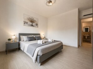 Une chambre à coucher moderne avec un lit, des tables de chevet et un tableau au mur.