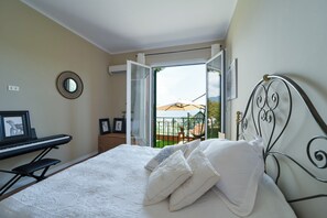 A bedroom with a bed, a piano, a mirror, and a view of a balcony with outdoor furniture. - The Bay Garden Apartment- Santa Margherita Ligure (Santa Margherita Ligure)