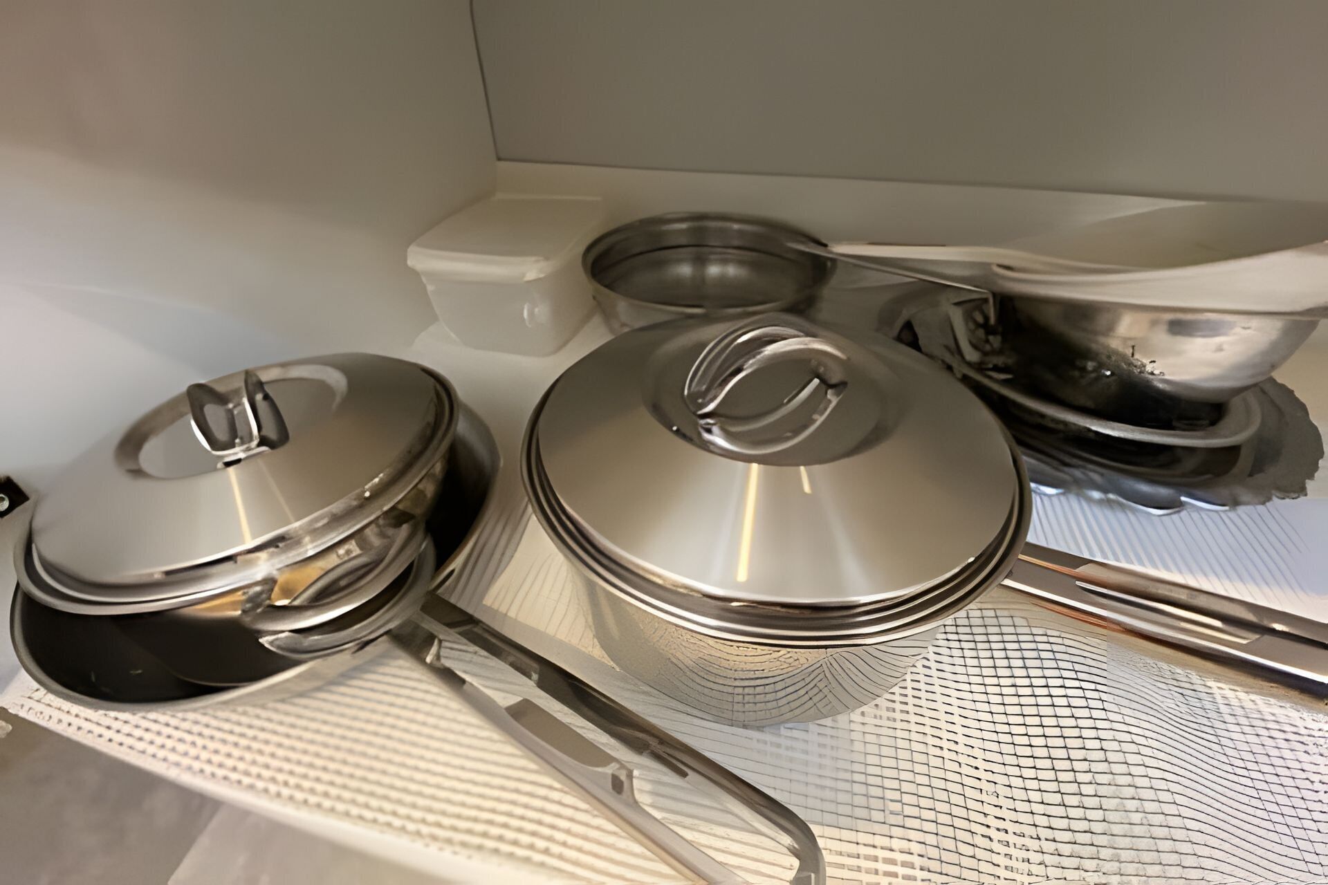 Stainless steel kitchenware on a white countertop.