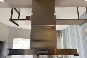 Uma cozinha moderna com exaustor de aço inoxidável e forno embutido.