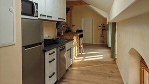 Een kleine keuken met moderne apparatuur, een houten aanrecht en een dakraam.