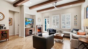 A living room with a fireplace, a television, and a sofa. - LV307 3BR-3BA Legacy Villas Gem with Mountain Views (La Quinta)