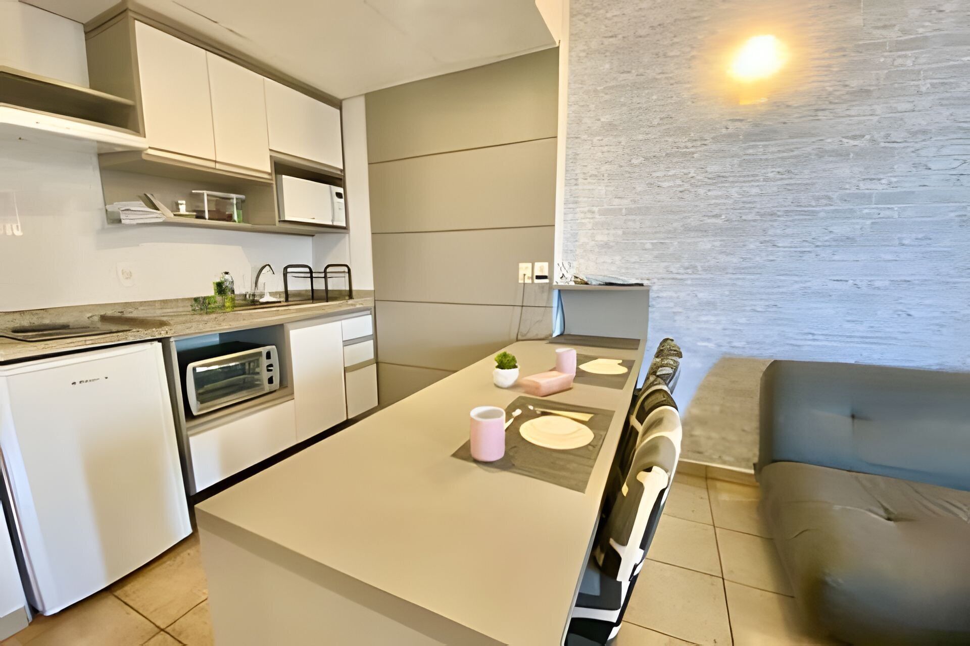 Una cocina moderna con comedor, que incluye horno empotrado, microondas y una pequeña isla con pileta.