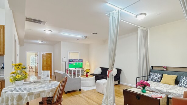 A modern living room with a dining area, a television, and a bed with curtains. - Beautiful Private room in a  2-bedroom apartment in vibrant Jersey City (Jersey City)