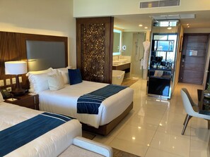 Ein Hotelzimmer mit zwei Betten, einem Schreibtisch, einem Stuhl, einem Badezimmer und einer Küchenzeile.