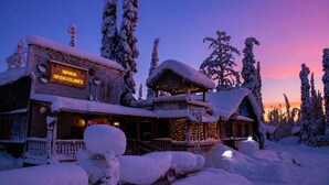 Una cabaña cubierta de nieve con un letrero que dice 'Wanha Waskoolimes'.
