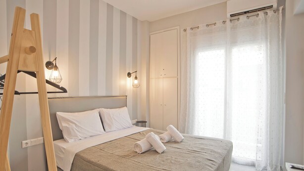 Ein Hotelzimmer mit einem Bett, einer Holzleiter, einem Kleiderschrank und einem Vorhangfenster.