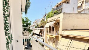 Ein Balkon mit einem Tisch, der f ür zwei Personen gedeckt ist, inklusive Teller, Besteck und Weingläsern.