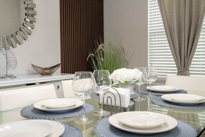 Une table à manger dressée avec des assiettes, des verres et un centre de table décoratif.