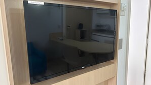 A modern kitchen with a large black refrigerator, a wooden countertop, and a built-in oven. - SHB Horizonte Azul Refúgio Inesquecível (Santos)