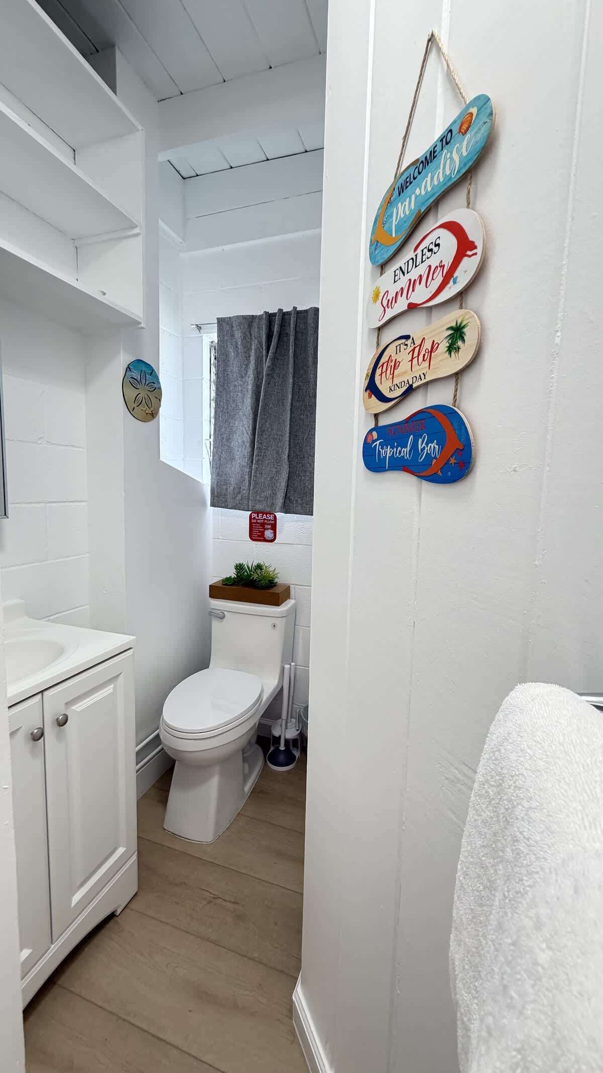 Een badkamer met toilet, wastafel en een handdoekhouder.