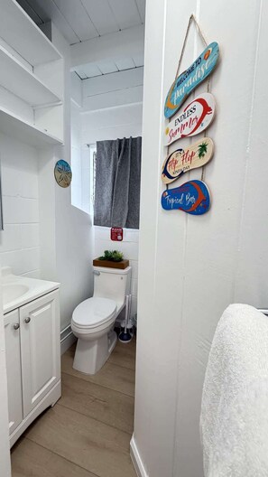 A bathroom with a toilet, sink, and a towel rack. - Rycroft Residence 1BR Apt with AC & Full Kitchen (Honolulu)