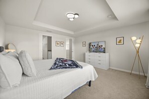 A bedroom with a bed, a dresser, a mirror, and a painting on the wall. - 5 BD/ 4 BA/ Solterra (7247OL) (Davenport)