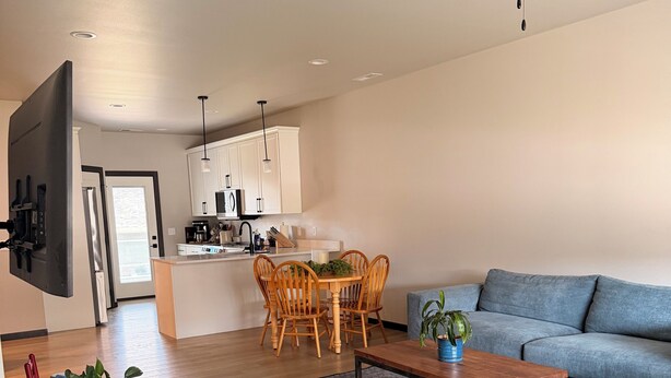 Un salon moderne comprenant un canapé, une table basse et un coin repas avec des chaises.