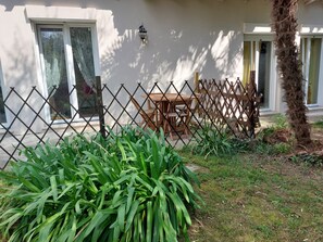 A fenced outdoor area with a table and chairs, a lamp post, and a building with windows and a door. - La Barchessa: A Plunge into Nature (Riva del Garda)