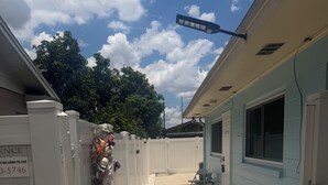 A pathway leading to a building with a white fence and a signboard. - The Blue Palace (Tampa)