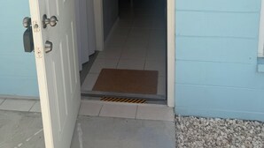 A doorway leading into a building with a tiled floor and a doormat. - The Blue Palace (Tampa)